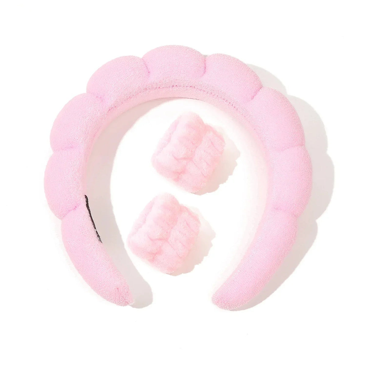 Pink plush headband with white accents on a white background